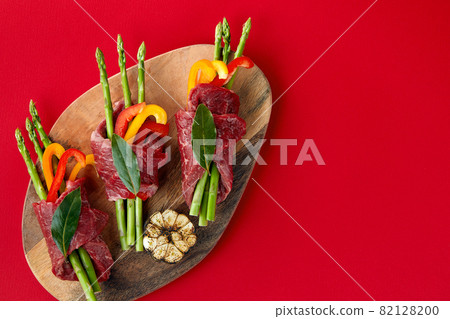 Baking pan with uncooked beef roulades and fresh vegetable trimmings ready for cooking on a white background Baking pan with uncooked beef roulades and fresh vegetable trimmings ready for cooking on a white background 82128200