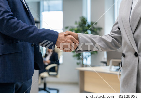 Handshake of two young business partners in office environment Handshake of two young business partners in office environment 82129955