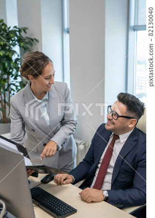 Elegant secretary consulting with her boss in office 82130040