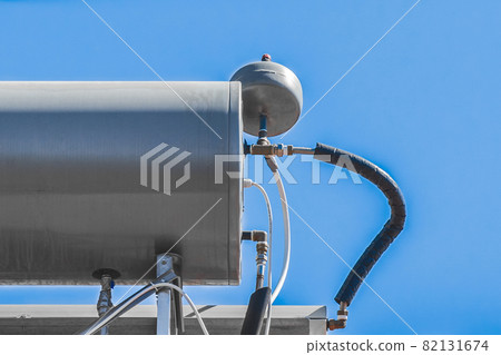 Water boiler heater tank system and hot technology on the roof of the house against the blue sky Water boiler heater tank system and hot technology on the roof of the house against the blue sky 82131674