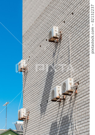 Air conditioning equipment for cooling of the air modern technologies on the wall of a white brick building against the blue sky Air conditioning equipment for cooling of the air modern technologies on the wall of a white brick building against the blue sky 82132237