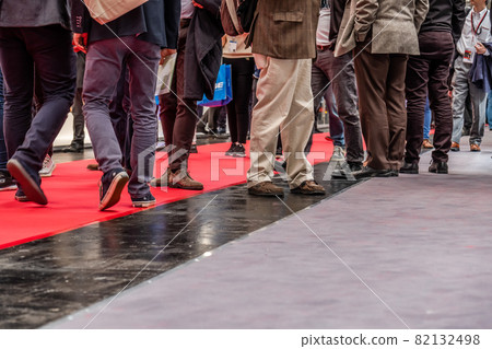 Low section of businessman and woman's legs walking on red carpet 82132498