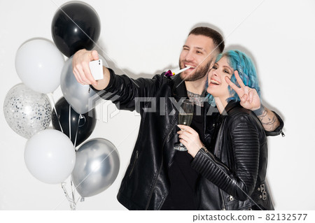 Happy anniversary. Excited beloved couple. Party celebration. Catch moments. Hipster joyful man and woman making selfie on smartphone with balloons decoration isolated white. Happy anniversary. Excited beloved couple. Party celebration. Catch moments. Hipster joyful man and woman making selfie on smartphone with balloons decoration isolated white. 82132577