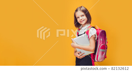Cute Schoolgirl preparing to go to school with backpack and tablet. Back to school concept Cute Schoolgirl preparing to go to school with backpack and tablet. Back to school concept 82132612