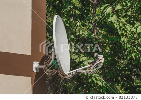 Satellite dish home TV suspended on the wall of the building in the outdoors 82133073