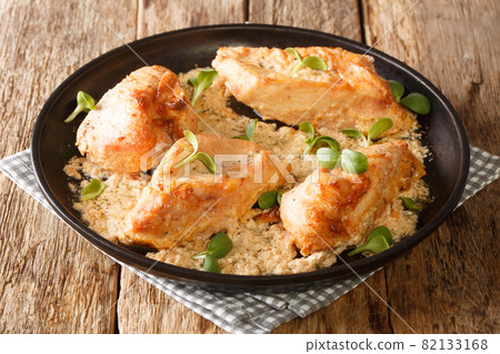 Homemade Amish chicken pieces baked with gravy closeup in the plate. Horizontal 82133168