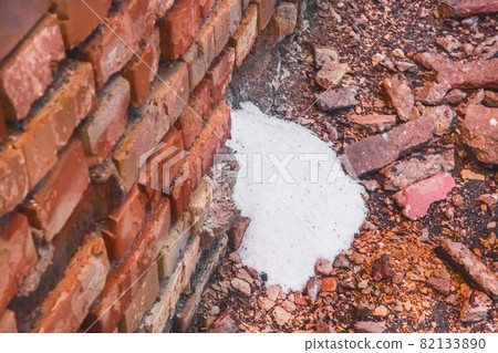White ammonia saltpeter, fertilizer woke up through the destroyed old brick wall of the industrial warehouse with fertilizer White ammonia saltpeter, fertilizer woke up through the destroyed old brick wall of the industrial warehouse with fertilizer 82133890