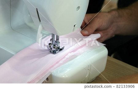 The dressmaker elaborately made thread pattern on a fine pink fabric. The dressmaker elaborately made thread pattern on a fine pink fabric. 82133906
