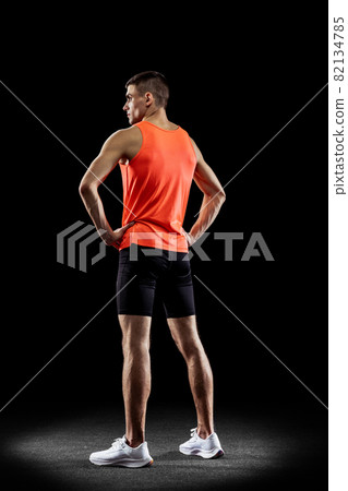 Full-length back view portrait of young male professional athlete isolated over black studio background Full-length back view portrait of young male professional athlete isolated over black studio background 82134785