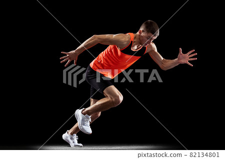 Full-length back view portrait of young male professional athlete running, training isolated over black studio background Full-length back view portrait of young male professional athlete running, training isolated over black studio background 82134801