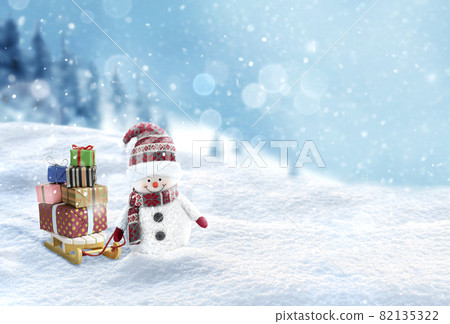 Cute Snowman with gift boxes on the sleigh on snowy landscape background 82135322