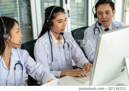 Doctor team wearing headset talking actively on video call in hospital clinic Doctor team wearing headset talking actively on video call in hospital clinic 82136252
