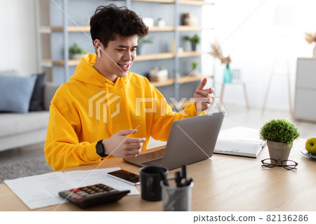 Asian man having video call using laptop and talking Asian man having video call using laptop and talking 82136286