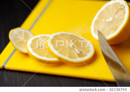 Sliced lemon on a yellow cutting board Sliced lemon on a yellow cutting board 82136743