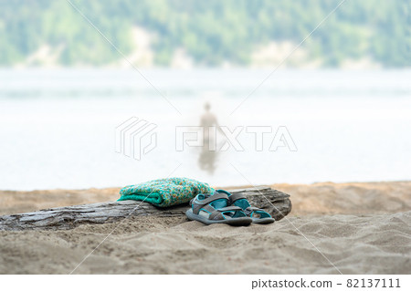swimming in the river on a hot summer day, focus on clothes lying on the shore swimming in the river on a hot summer day, focus on clothes lying on the shore 82137111