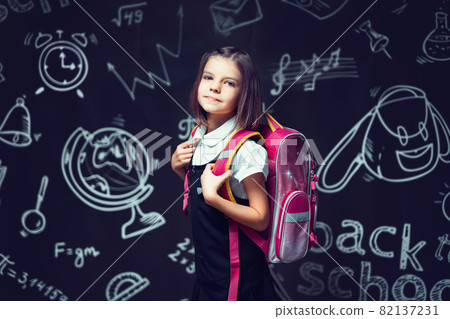 Cute caucasian schoolgirl preparing to go to school with backpack. Back to school concept Cute caucasian schoolgirl preparing to go to school with backpack. Back to school concept 82137231