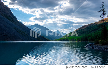 Clouds are reflected in the water of the Shavlinskoye lake in the Altai Republic. Clouds are reflected in the water of the Shavlinskoye lake in the Altai Republic. 82137284