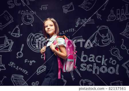 Cute Schoolgirl preparing to go to school with backpack. Back to school concept Cute Schoolgirl preparing to go to school with backpack. Back to school concept 82137561