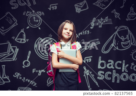 Cute pupil preparing to go to school with backpack and tablet in hands. Back to school concept Cute pupil preparing to go to school with backpack and tablet in hands. Back to school concept 82137565