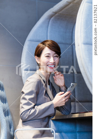 在個人展位使用智能手機的女性 圖片合作：WEEK Shibadaimon（Sun Frontier Fudousan） 82137621