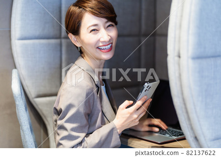 在個人展位使用智能手機的女性 圖片合作：WEEK Shibadaimon（Sun Frontier Fudousan） 82137622