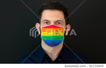 Man wearing a LGBT rainbow pride flag colors protective face mask. 82138040
