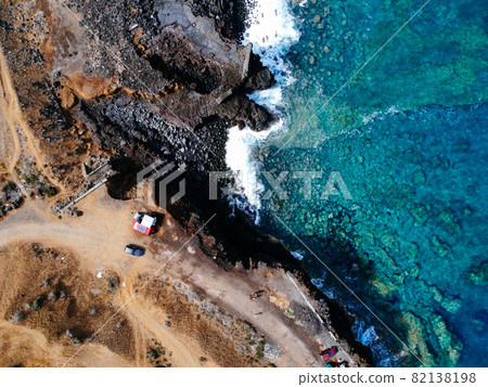 Aerial view of rocks and sea waves in a volcanic landscape with lava Aerial view of rocks and sea waves in a volcanic landscape with lava 82138198