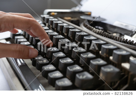 People hands typing an old Thai traditional typewriter. Classic vintage antique manual typing machine isolated on white background. 19th century item. Lifestyle 82138626