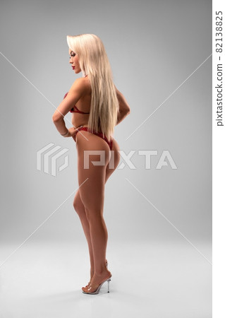 Alluring woman in red bikini and high heels in studio Alluring woman in red bikini and high heels in studio 82138825