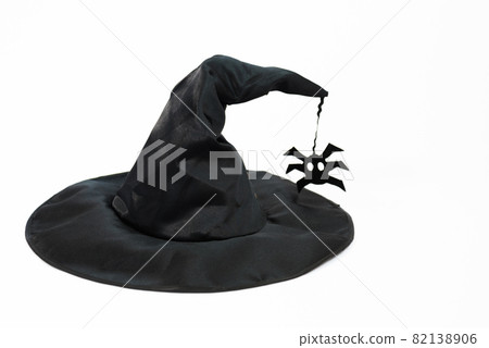 Black witch hat. Hat on a white background. A spider is attached to the hat. Witchcraft and magic. Concept Black witch hat. Hat on a white background. A spider is attached to the hat. Witchcraft and magic. Concept 82138906