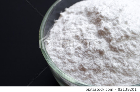 Baking soda in glass bowl on dark background. 82139201