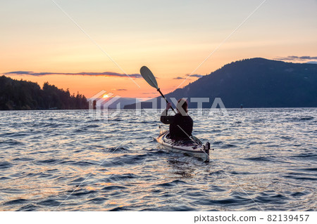 Adventurous Woman on Sea Kayak paddling in the Pacific Ocean. Adventurous Woman on Sea Kayak paddling in the Pacific Ocean. 82139457