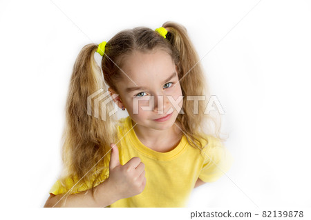 Little blonde girl in a yellow t-shirt makes gestures, raising her fingers, isolated on a white background. Childhood lifestyle concept Little blonde girl in a yellow t-shirt makes gestures, raising her fingers, isolated on a white background. Childhood lifestyle concept 82139878