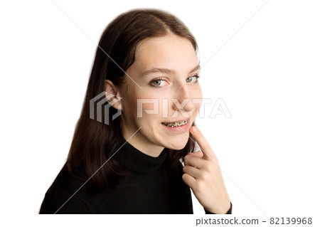 Smiling teenage girl with braces. Metal braces close-up on the teeth. Smiling teenage girl with braces. Metal braces close-up on the teeth. 82139968