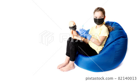 The girl plays a doctor with a doll. The reality of the coronavirus in the lives of children. Injection against covid19. The girl plays a doctor with a doll. The reality of the coronavirus in the lives of children. Injection against covid19. 82140013