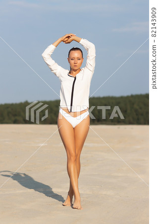 Dreamy young woman in white wear standing in nature 82143909