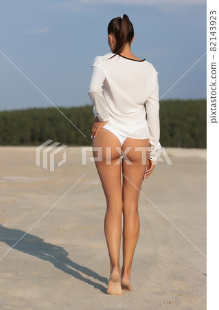 Dreamy young woman in white wear standing in nature 82143923