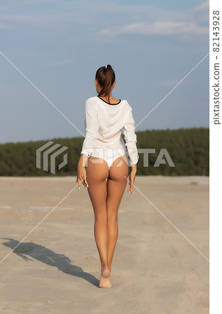 Dreamy young woman in white wear standing in nature 82143928