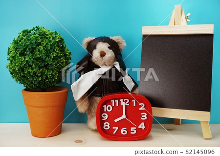 teddy bear and alarm clock with space copy on wooden background 82145096