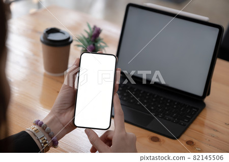 A Woman hand holding smartphone device with blank screen. Blank screen for your advertising. 82145506