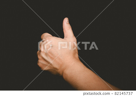The man's hand that thumbs up is a symbol of admiration on black background 82145737