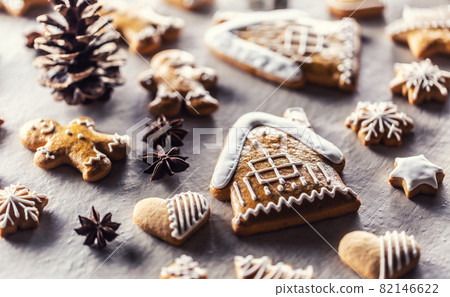 House with gingerbread and other Christmas cookies along with cinnamon and pine cones 82146622