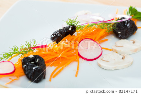 Image of salad from fresh carrot, radishes and prunes served at plate Image of salad from fresh carrot, radishes and prunes served at plate 82147171