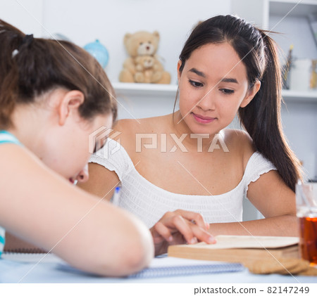 Two classmates doing homework together Two classmates doing homework together 82147249