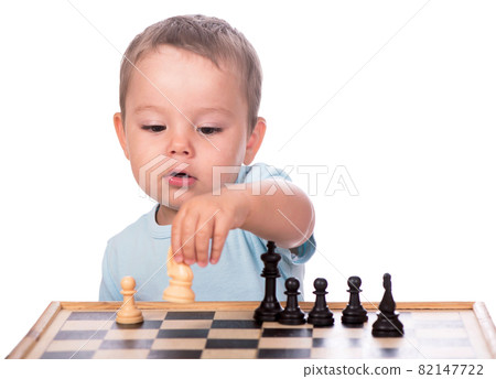 little boy staring at the chess pieces isolated on white background little boy staring at the chess pieces isolated on white background 82147722