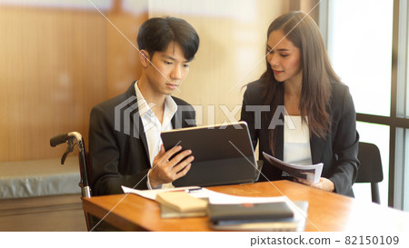Asian female business manager coaching her new disabled person 82150109