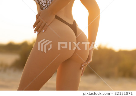 Crop woman with firm buttocks on beach Crop woman with firm buttocks on beach 82151871