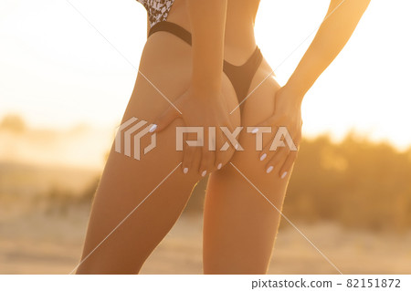 Crop woman with firm buttocks on beach Crop woman with firm buttocks on beach 82151872