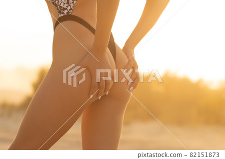 Crop woman with firm buttocks on beach Crop woman with firm buttocks on beach 82151873