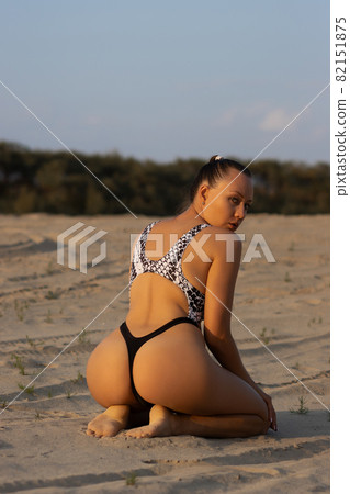 Graceful woman in bikini on sandy beach Graceful woman in bikini on sandy beach 82151875